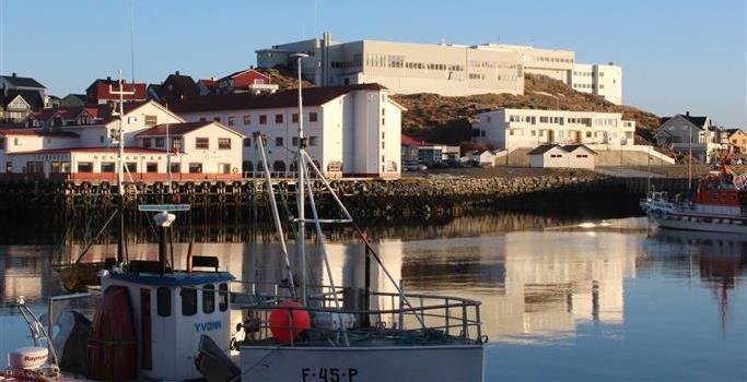 Bilde av havna i Honningsvåg og Nordkapp videregående skole i bakgrunn.  - Klikk for stort bilde
